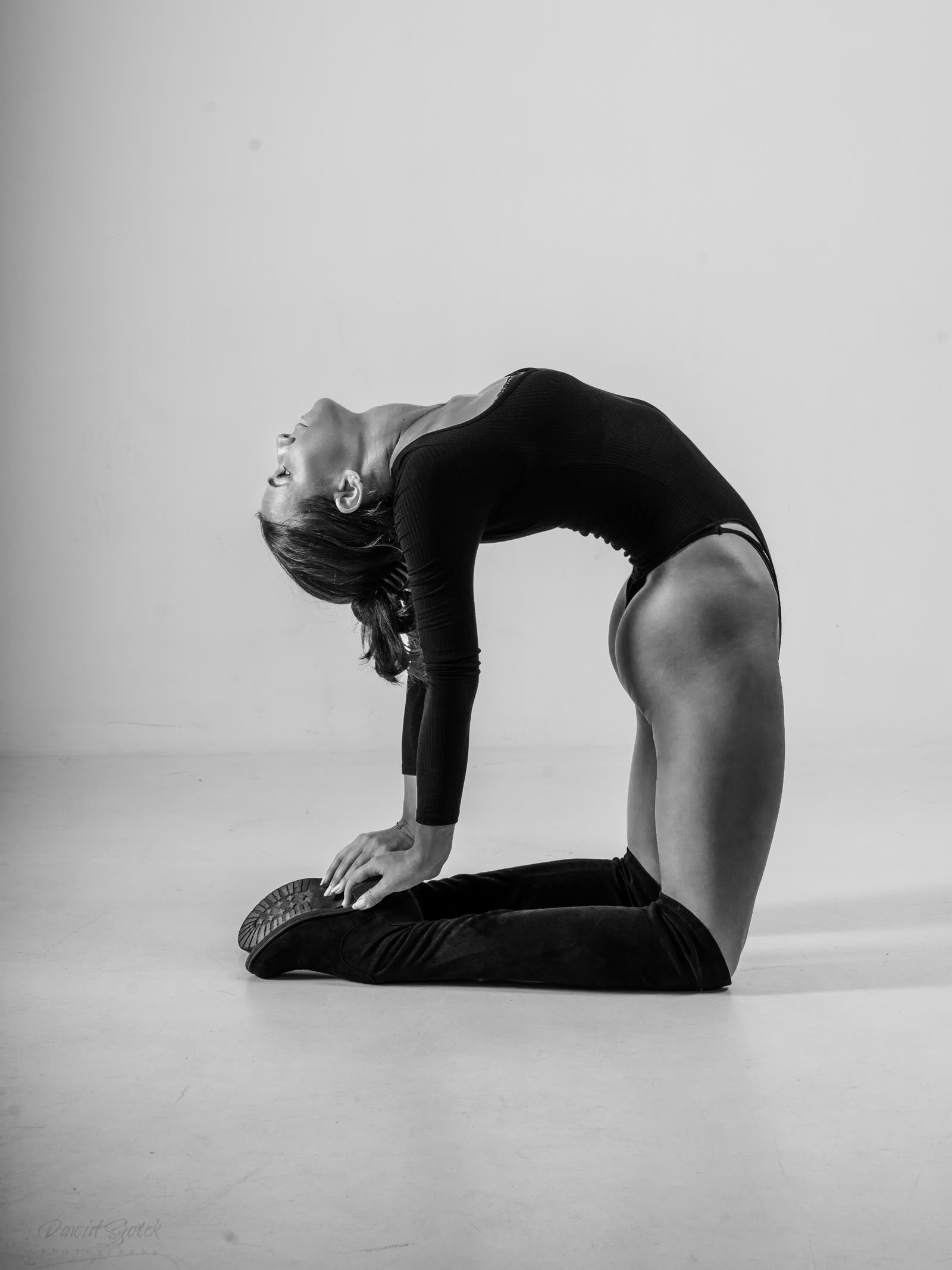 Black and white portrait session — woman in a camel pose, photo studio Kraków