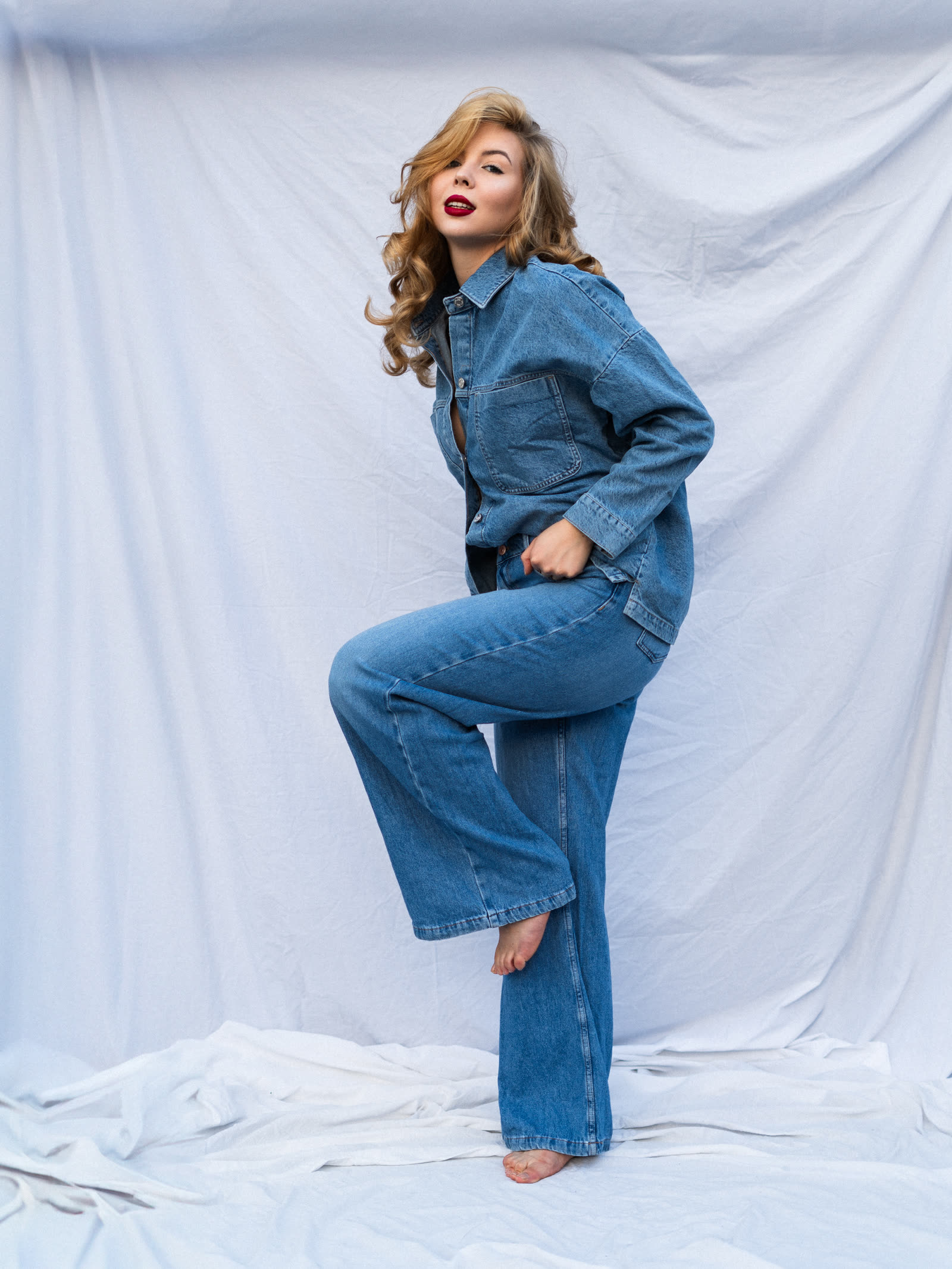 Editorial fashion session — woman in total denim look on a white background, photo shoot Kraków