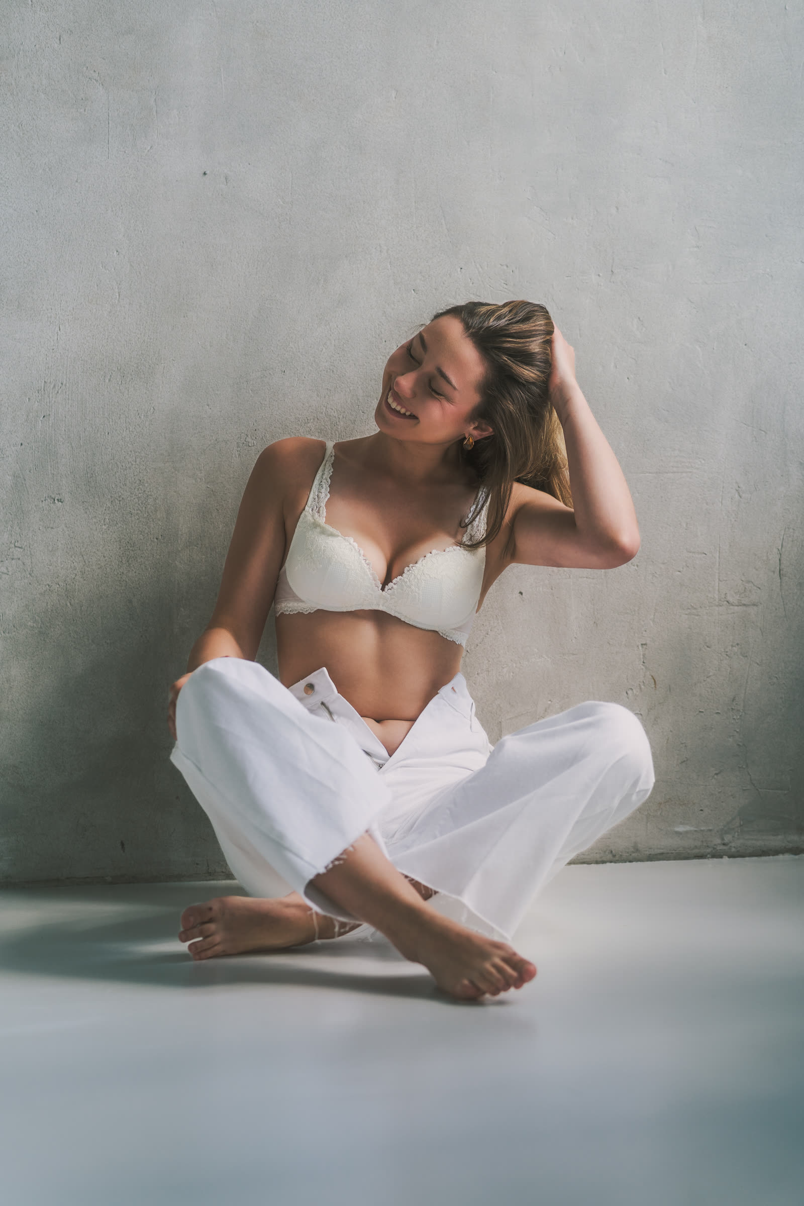 Women's studio session — woman smiling on a white background, natural light, portrait session Kraków